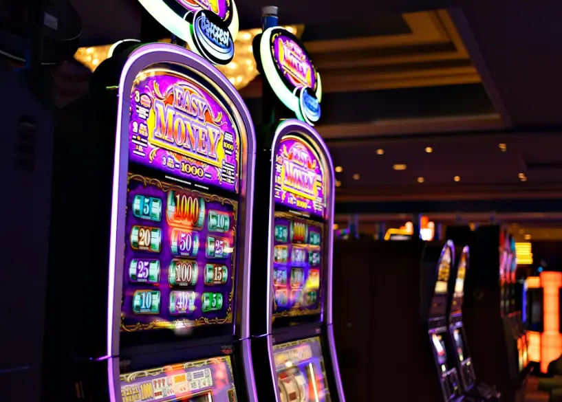 Close-up of slot machines with a Easy Money theme and colorful lights in a casino